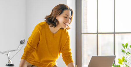 Frau verwaltet Ihren Onlineshop am Laptop